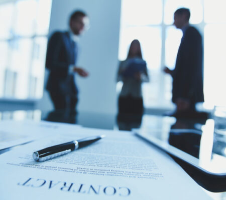 Close-up of contract with business people in the background