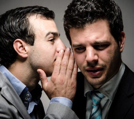 image of a young professional whispering to another